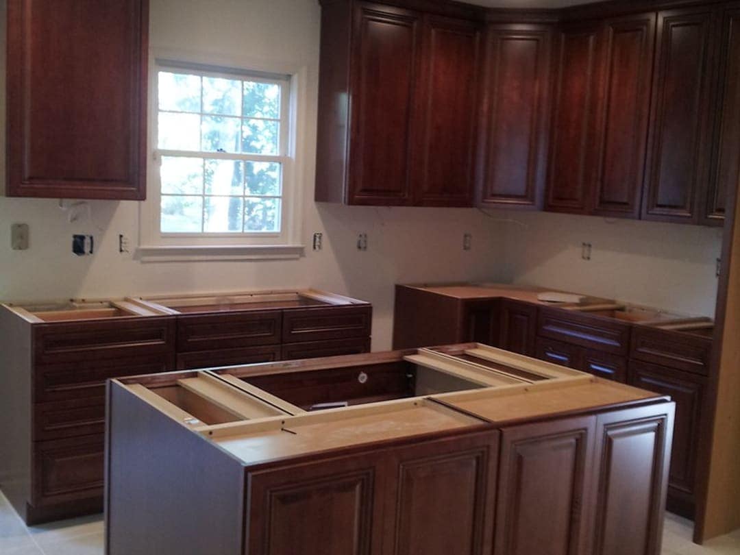 Kitchen in progress: new cabinets set, countertops not yet installed, open boxes on the wall